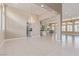 Open-concept living area with tile floors, chandelier, and ample natural light at 5576 Buena Martina Way, Las Vegas, NV 89141