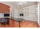 Executive office with hardwood floors, built-in shelving, storage, and a large curved desk at 5576 Buena Martina Way, Las Vegas, NV 89141