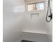 Modern shower with white tile, built-in bench, mosaic floor, and a window for natural light at 5576 Buena Martina Way, Las Vegas, NV 89141