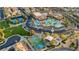 Community aerial view featuring a pool, tennis and basketball courts, green spaces, and tree coverage at 589 Via Paladini, Henderson, NV 89011