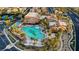 An aerial view of a turquoise community pool bordered with palm trees, lawn chairs, and landscaped walking paths at 589 Via Paladini, Henderson, NV 89011