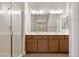 Bathroom vanity with double sinks, a large mirror, and a walk-in shower at 589 Via Paladini, Henderson, NV 89011