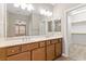 Bathroom featuring a double sink vanity, large mirror, and access to a walk-in closet at 589 Via Paladini, Henderson, NV 89011