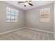 Bedroom with two windows, a ceiling fan, and neutral-toned carpet, offering a cozy and inviting space at 589 Via Paladini, Henderson, NV 89011
