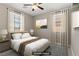 A staged bedroom with a bed, side tables, large windows, and a ceiling fan offers a peaceful retreat at 589 Via Paladini, Henderson, NV 89011