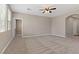 Spacious living room with neutral carpet, a ceiling fan, and large windows for ample natural light at 589 Via Paladini, Henderson, NV 89011
