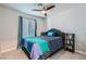 A cozy bedroom with a full-sized bed, a ceiling fan, and natural light at 6309 Miraloma St, Las Vegas, NV 89108