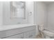 Modern bathroom features a gray vanity, white countertop, mirror, and a bathtub with white tile surround at 659 D Ave, Boulder City, NV 89005