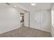 Bright bedroom featuring neutral carpet, white walls, and a doorway to an adjacent living area at 659 D Ave, Boulder City, NV 89005