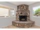 Close-up of a stone fireplace in the living room with light wood floors and bright light at 659 D Ave, Boulder City, NV 89005