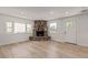 Bright living room featuring a stone fireplace, light wood flooring, and ample natural light at 659 D Ave, Boulder City, NV 89005