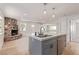 Open-concept living area features a stone fireplace and modern island with seating at 659 D Ave, Boulder City, NV 89005