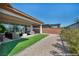The backyard shows patio furniture on artificial turf, with a gravel space beyond the patio at 6684 Regency Stone Way, Las Vegas, NV 89148
