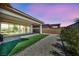 A view of a backyard reveals an extended outdoor living space, artificial turf, and a gravel yard at 6684 Regency Stone Way, Las Vegas, NV 89148