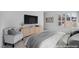 Staged primary bedroom featuring neutral color palette, large TV, and window shutters at 6684 Regency Stone Way, Las Vegas, NV 89148