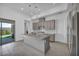 Open kitchen with gray island flows to backyard through sliding glass doors at 6684 Regency Stone Way, Las Vegas, NV 89148