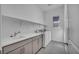 Well-lit laundry room with modern washer, dryer, sink, and ample storage space at 6684 Regency Stone Way, Las Vegas, NV 89148