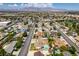 Wide aerial view showcasing a residential area with lush greenery, mountains, and single-Gathering homes with private pools at 6710 Rocking Horse Ave, Las Vegas, NV 89108