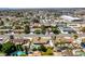 An aerial view of a neighborhood featuring single-Gathering homes, palm trees and community amenities, with the mountains visible in the distance at 6710 Rocking Horse Ave, Las Vegas, NV 89108