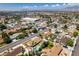 An aerial view shows a neighborhood featuring single-Gathering homes, palm trees and community amenities, with the mountains visible in the distance at 6710 Rocking Horse Ave, Las Vegas, NV 89108