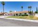 Inviting single-story home with a two-car garage, lush green lawn, palm trees, and a covered porch, reflecting a cozy and well-kept residence at 6710 Rocking Horse Ave, Las Vegas, NV 89108