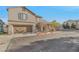 Inviting home featuring an attached garage, neutral stucco, and landscaped front yard, on a sunny day at 6804 Tropicaire St, Las Vegas, NV 89149