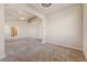 Large living room features neutral carpet, ceiling fan, and archways to other rooms at 6804 Tropicaire St, Las Vegas, NV 89149