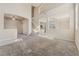An expansive living area featuring neutral carpeting, lofty ceilings, and view into the kitchen at 6804 Tropicaire St, Las Vegas, NV 89149