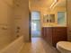Bathroom with vanity, toilet, and shower-tub combo with tiled walls at 7469 Margollini St, Las Vegas, NV 89148