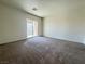 A vacant bedroom with carpeting and a sliding glass door to the outside at 7469 Margollini St, Las Vegas, NV 89148