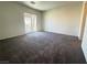 Spacious bedroom with neutral walls, plush carpeting, and a sliding glass door to a balcony at 7469 Margollini St, Las Vegas, NV 89148