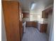 Efficient kitchen space with wooden cabinets, white appliances and gray flooring at 7469 Margollini St, Las Vegas, NV 89148
