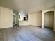 Spacious open-concept living area with gray wood-look floors flowing into the adjacent dining and kitchen spaces at 7469 Margollini St, Las Vegas, NV 89148