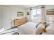 Comfortable bedroom with decorative pillows, a dresser, and a large window offering natural light and pleasant views at 7925 Pandora Sky St # 392, Las Vegas, NV 89084