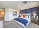 Spacious bedroom with a decorative blue accent wall, and a plush bed illuminated by natural light at 7935 Pandora Sky St # 393, North Las Vegas, NV 89084
