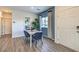 Bright dining area features wood-look floors, a white table with navy chairs, and natural light at 7935 Pandora Sky St # 393, North Las Vegas, NV 89084