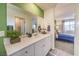 The bathroom features a bright vanity with a large mirror, a potted plant, and leads to the bedroom at 7945 Pandora Sky St # 371, North Las Vegas, NV 89084