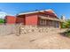 View of back of home with red siding and stone facade in backyard featuring desert landscaping at 812 Pyramid Dr, Las Vegas, NV 89107