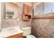 This bathroom features tiled walls, a wood vanity and cabinet, and large mirror at 812 Pyramid Dr, Las Vegas, NV 89107