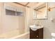 Bathroom view of a tub with a shower, vanity, mirror, and window at 812 Pyramid Dr, Las Vegas, NV 89107