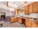 Open kitchen with wooden cabinets, a view to the dining area, and standard appliances at 812 Pyramid Dr, Las Vegas, NV 89107