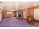 Spacious living room featuring a stone fireplace, wood paneling, and large windows at 812 Pyramid Dr, Las Vegas, NV 89107