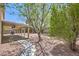 Relaxing backyard with a covered patio, outdoor kitchen, and serene landscaping at 825 Cornerstone Pl, North Las Vegas, NV 89031