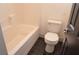 Bathroom featuring a tub with white tile surround, toilet, and dark tile flooring at 825 Cornerstone Pl, North Las Vegas, NV 89031