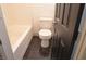 Bathroom featuring a tub with white tile surround, toilet, and dark tile flooring at 825 Cornerstone Pl, North Las Vegas, NV 89031