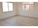 Bright bedroom featuring laminate floors and two windows with blinds at 825 Cornerstone Pl, North Las Vegas, NV 89031