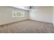 Spacious, carpeted bedroom with a ceiling fan and natural light streaming in from a window at 825 Cornerstone Pl, North Las Vegas, NV 89031