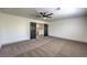 Carpeted bedroom featuring double doors and a ceiling fan, creating an inviting space at 825 Cornerstone Pl, North Las Vegas, NV 89031