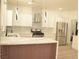 Bright kitchen with stainless steel appliances, custom cabinets, marble countertops, a unique backsplash, and an eye-catching island at 825 Cornerstone Pl, North Las Vegas, NV 89031