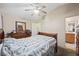 This bedroom includes neutral walls, carpet, ceiling fan, wood dresser, and access to a bathroom at 845 Bladensburg St, Las Vegas, NV 89110